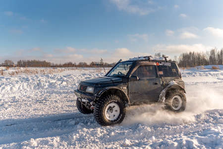 Russia, Novosibirsk-January 20, 2020 Four-wheel drive SUV "Suzuki Escudo" with large wheels goes quickly raising a snowstorm on the road in winter in the sun.のeditorial素材