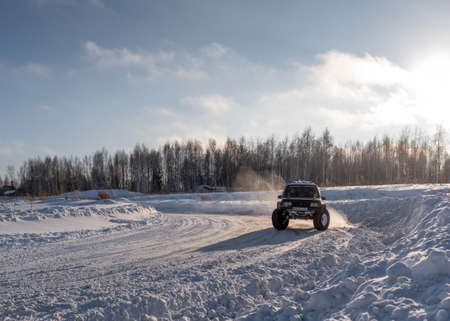 Russia, Novosibirsk-January 20, 2020 Four-wheel drive 4x4 SUV "Suzuki Escudo" with large wheels goes quickly raising a snowstorm on the road in winter in the sun.のeditorial素材