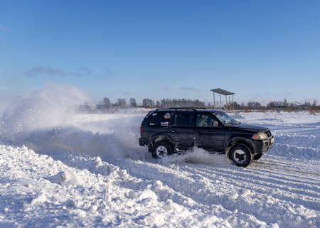 Russia, Novosibirsk-January 20, 2020 4x4 all-wheel drive modified SUV "Mitsubishi Pajero sport" goes quickly lifting snow in winter on the road.のeditorial素材