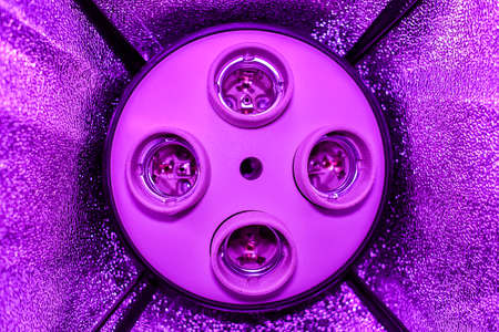 Four empty cartridges in a ceiling without lamps in a Studio softbox with reflectors stand in the lilac gloom.の写真素材