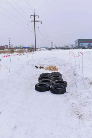 Russia, Novosibirsk-March 23, 2020. Old tires lie on the obstacle course in the background of a car dealership before the holidays for customers.のeditorial素材