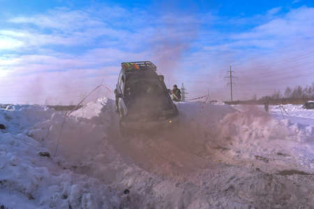 Russia, Novosibirsk-March 13, 2020. Offroad SUV "Suzuki Escudo" 4x4 quickly actively moves down the snowy mountain in the brown smoke in winter.のeditorial素材