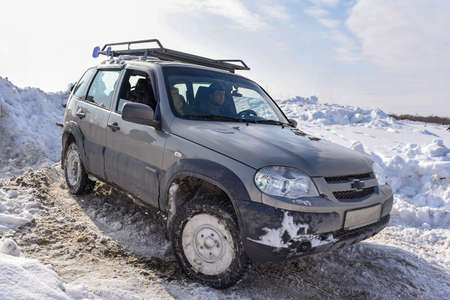 Russia, Novosibirsk-March 23, 2020. Russian offroad SUV "Lada Niva Chevrolet 4x4" quickly with splashes of snowstorm rides on the snow in winter on the turn.のeditorial素材