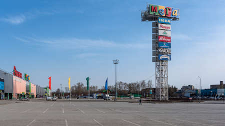 Novosibirsk, Russia-April 12, 2020. Empty Parking without cars and people at the Mega IKEA hypermarket due to the quarantine of the covid19 virus epidemic with a lone woman in a mask and grocery bags in her hands.のeditorial素材
