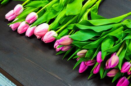 pink tulips on a wooden tableの写真素材