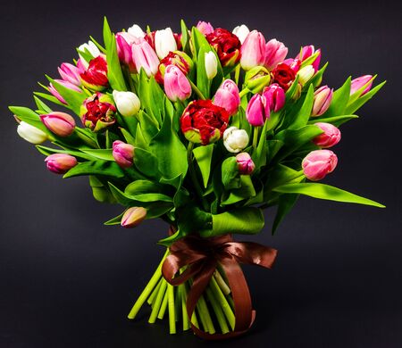 bright bouquet of tulips on a dark backgroundの写真素材