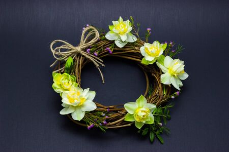 wreath decorated with daffodils on backgroundの写真素材