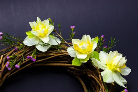 wreath decorated with daffodils on background