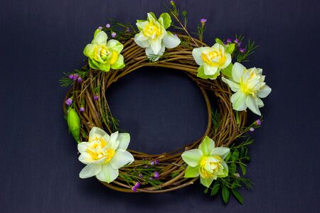 wreath decorated with daffodils on backgroundの写真素材