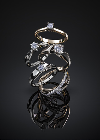 engagement diamond wedding ring group isolated on black background.の写真素材