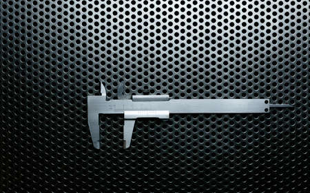 Vernier caliper on metal perforated surface with highlightsの写真素材