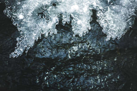 Ice formations growing outward along the small frozen mountain creek