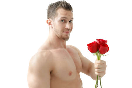 Sexy man gives a rose on a white background with a beautiful light. Isolated on white backgroundの写真素材