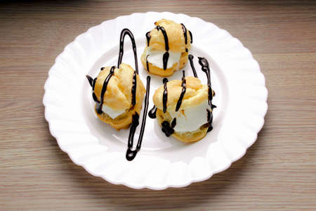 Profiteroles with ice cream with chocolateの写真素材