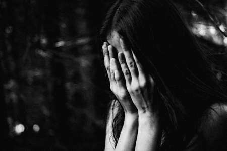 Ghost covered with a white ghost sheet on a rural path. Grainy textured imageの写真素材