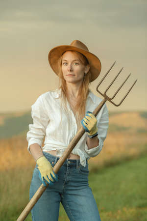 Country woman in field with pitchfork. Harvest festivalの写真素材