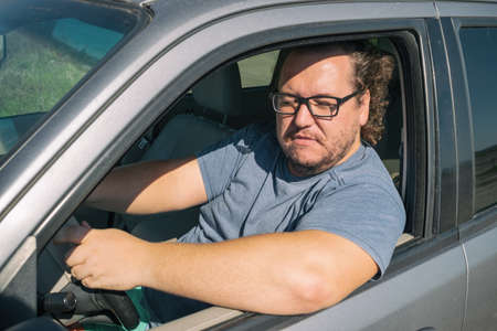 Angry fat man in the car. Road and stress. Traffic incidentの写真素材