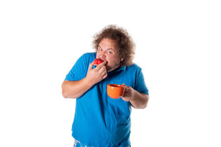 Funny fat man with mug eating cake. Happy birthday. Joy and funの写真素材