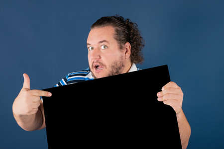 Fat funny man holding a black writing board