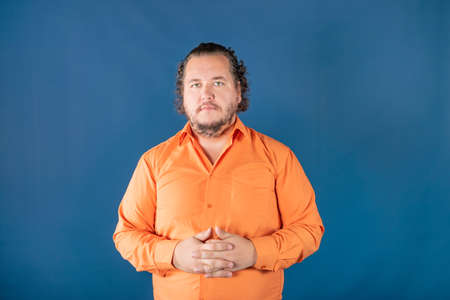 Sad fat man posing in the studio. Health problems. Excess weightの写真素材