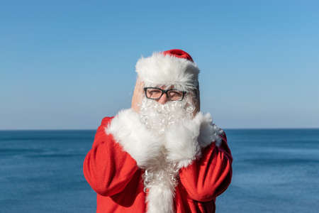 Santa's vacation at sea. Relaxing on the beachの写真素材