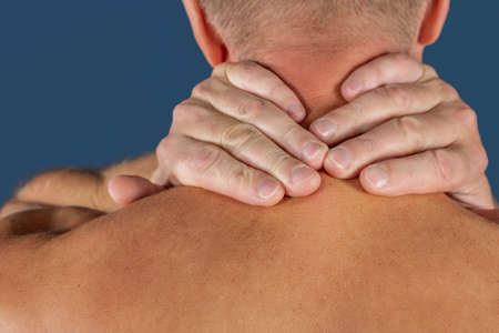Man holding his neck trying to relieve pain