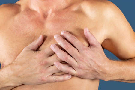Severe heartache, man suffering from chest pain, having heart attack or painful cramps, pressing on chest with painful expression.の写真素材