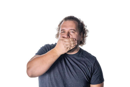 Portrait of amazed man covering his mouth over white background. Say no evil concept