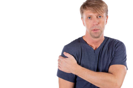 Man holding his sore shoulder trying to relieve painの写真素材