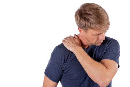 Man holding his sore shoulder trying to relieve painの写真素材