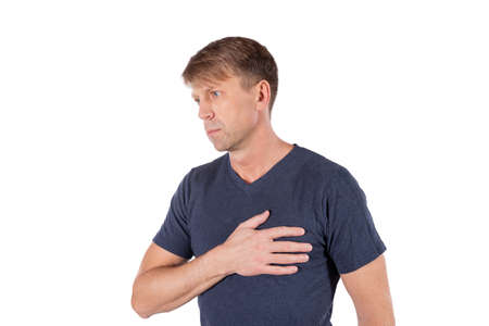 Severe heartache, man suffering from chest pain, having heart attack or painful cramps, pressing on chest with painful expression.の写真素材