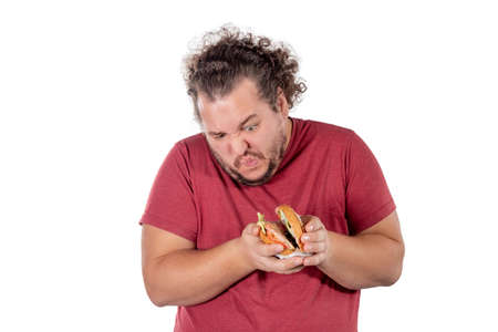 Funny fat man eating hamburger. Fast food, unhealty eatの写真素材