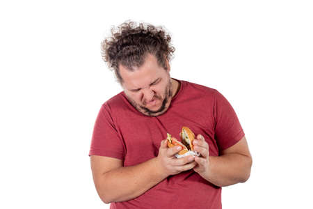 Funny fat man eating hamburger. Fast food, unhealty eat. Overweight and health problemsの写真素材