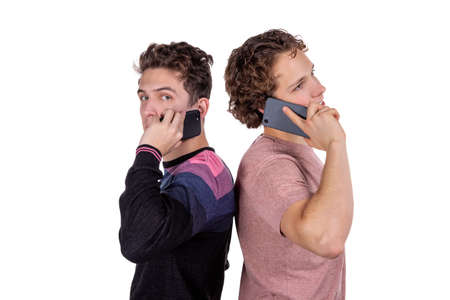 Portrait of a two happy young men using mobile phonesの写真素材