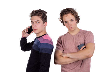 Portrait of a two happy young men using mobile phonesの写真素材
