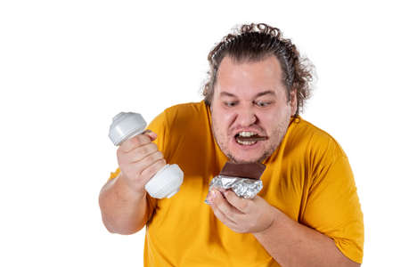 Funny fat man eating unhealthy food and trying to take exercise isolatedの写真素材