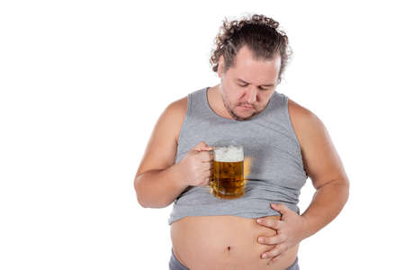 Funny fat man feeling happy and relaxed, holding fresh cold beer in his handsの写真素材