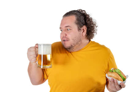 Funny fat man eating burger and drinking alcohol beverageの写真素材