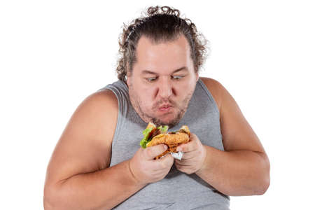 Portrait of funny fat man eating fast food burger isolated