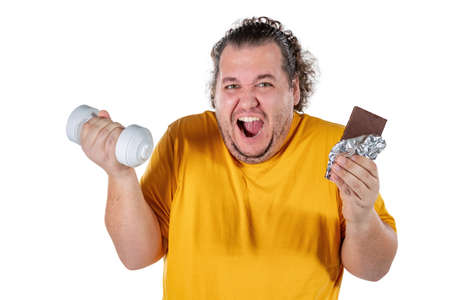 Funny fat man eating unhealthy food and trying to take exercise isolatedの写真素材
