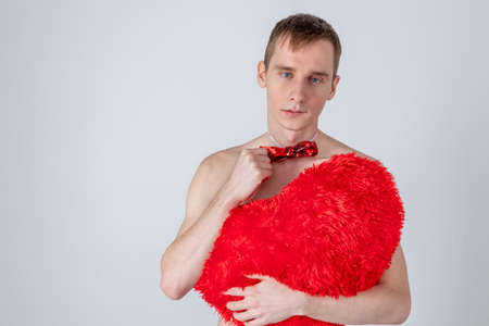 Handsome guy hold big red heart on white background. Love and romantic concept.の写真素材