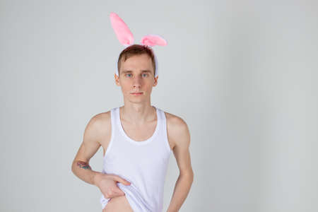 Handsome guy with bunny ears holding basket with eggsの写真素材