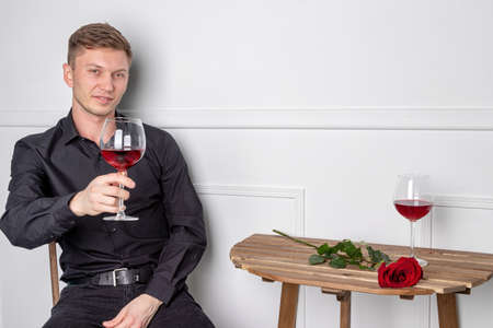 Young handsome man sitting by table in cafeの写真素材