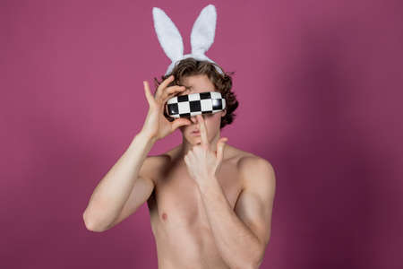 Funny  guy wearing bunny ears and mask over pink backgroundの写真素材