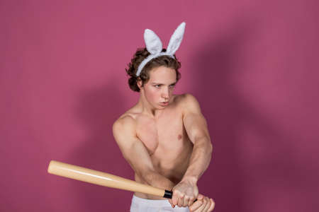 Funny  guy wearing bunny ears with baseball batの写真素材