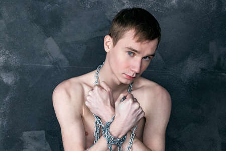 Handsome skinny guy holding a chain