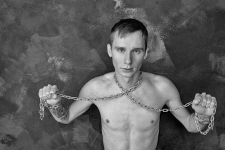 Handsome skinny guy holding a chain