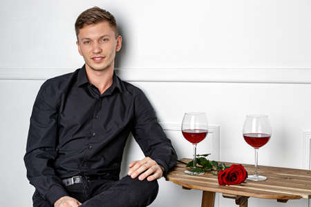Young handsome man sitting by table in cafeの写真素材