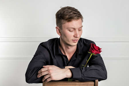 Handsome man wearing black shirt holding a roseの写真素材