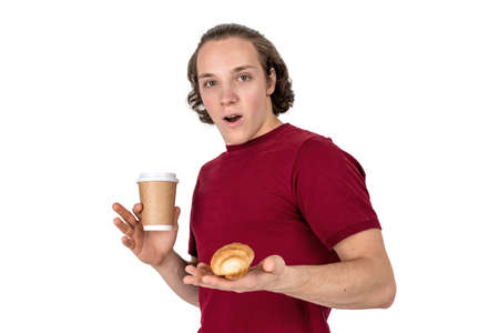 Young handsome man drink coffee and eating croissant. French breakfast and morning coffee